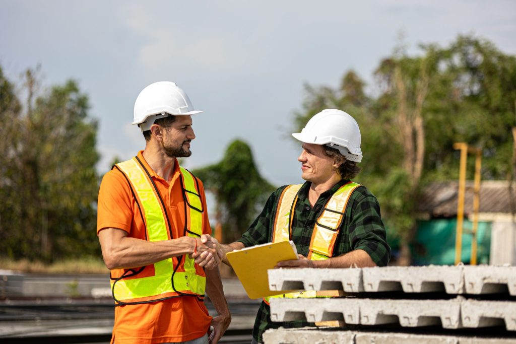 Construction workers shake hands after a deal.
