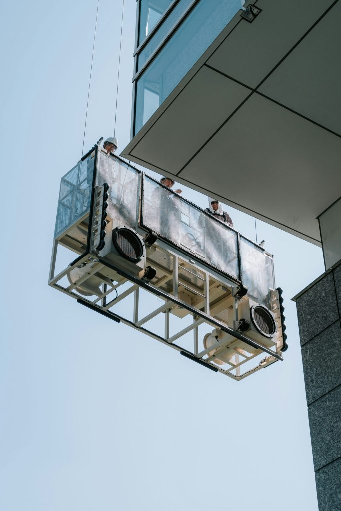 Workers on a suspended platform cleaning skyscraper windows